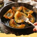 acorn squash recipe - Two halves of roasted acorn squash filled with brown sugar, spices, and pecans, served on a white plate.