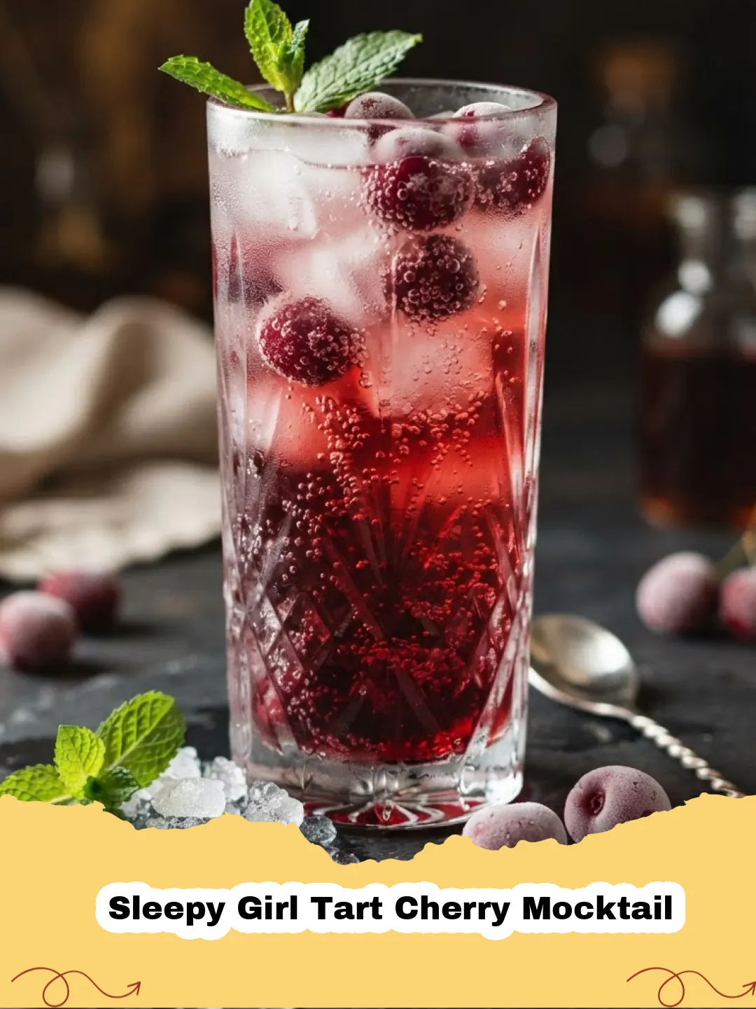 A glass of Sleepy Girl Tart Cherry Mocktail with ice, garnished with fresh cherries and a lime slice on a cozy evening setting.